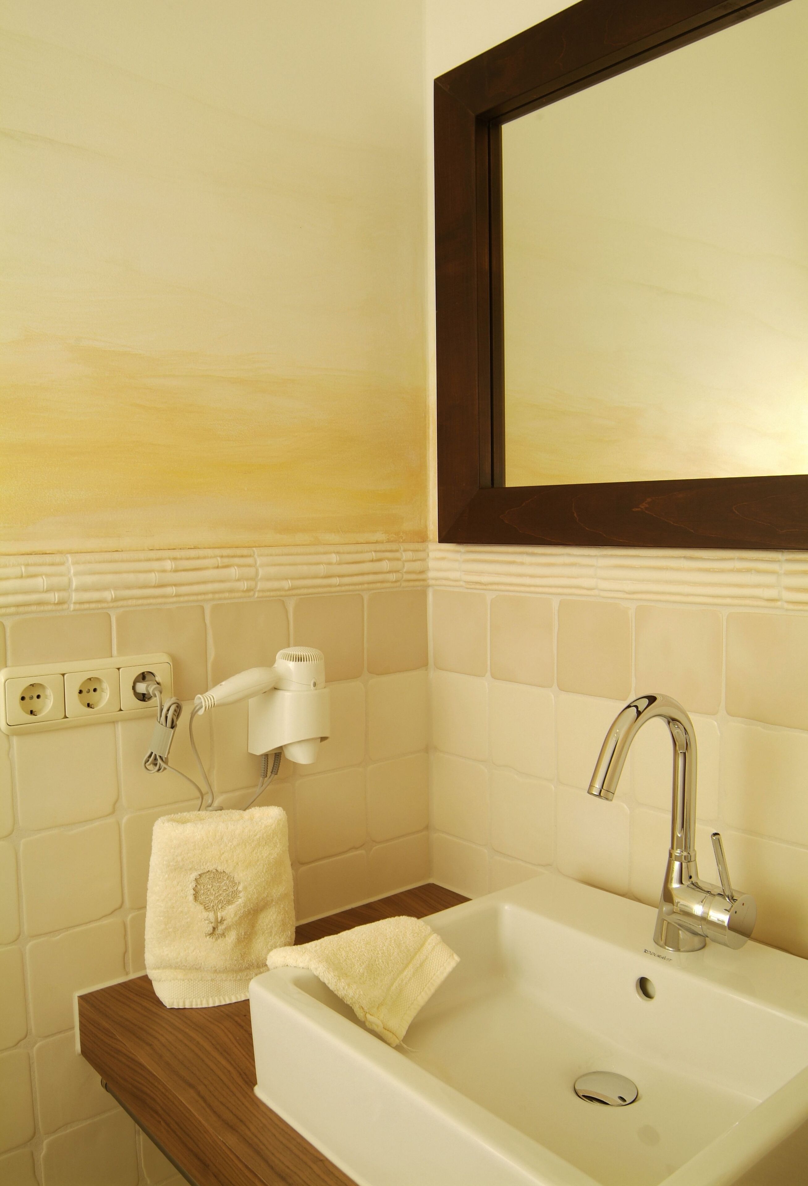A bathroom with a white sink, a mirror, and a towel rack.