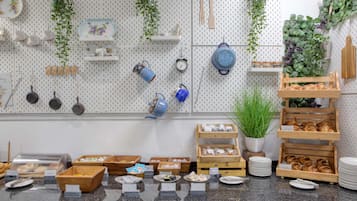 A breakfast buffet with various food items and utensils displayed on a counter.