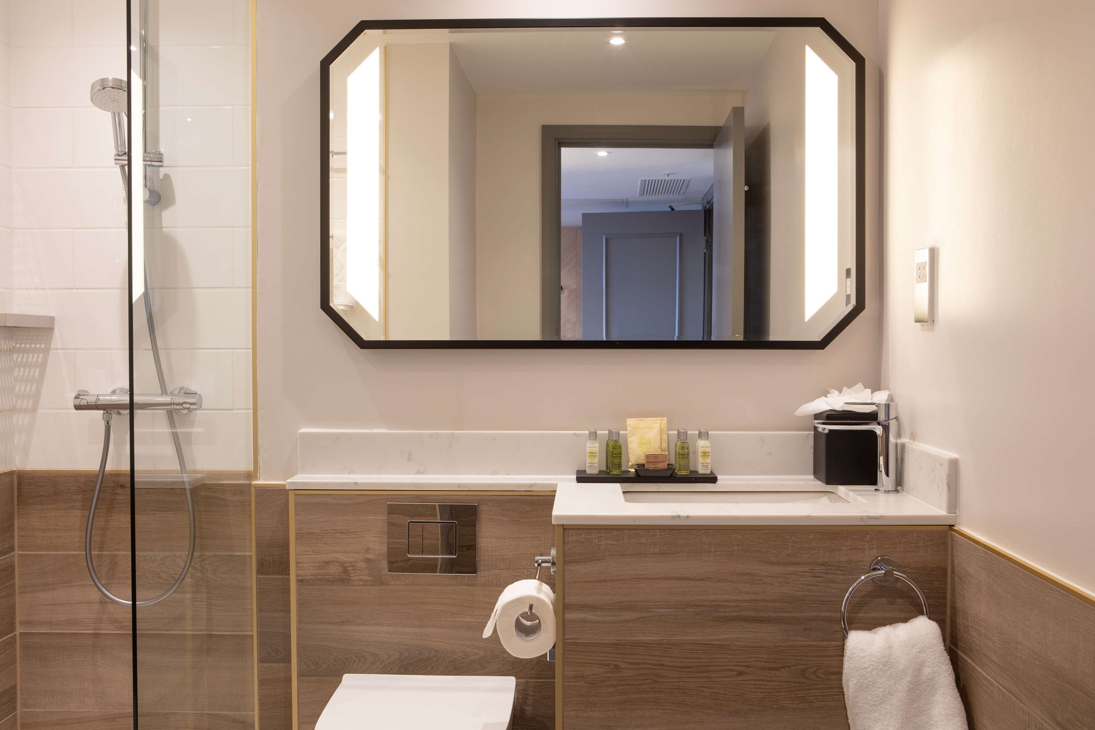 A modern bathroom with a shower, toilet, and sink.