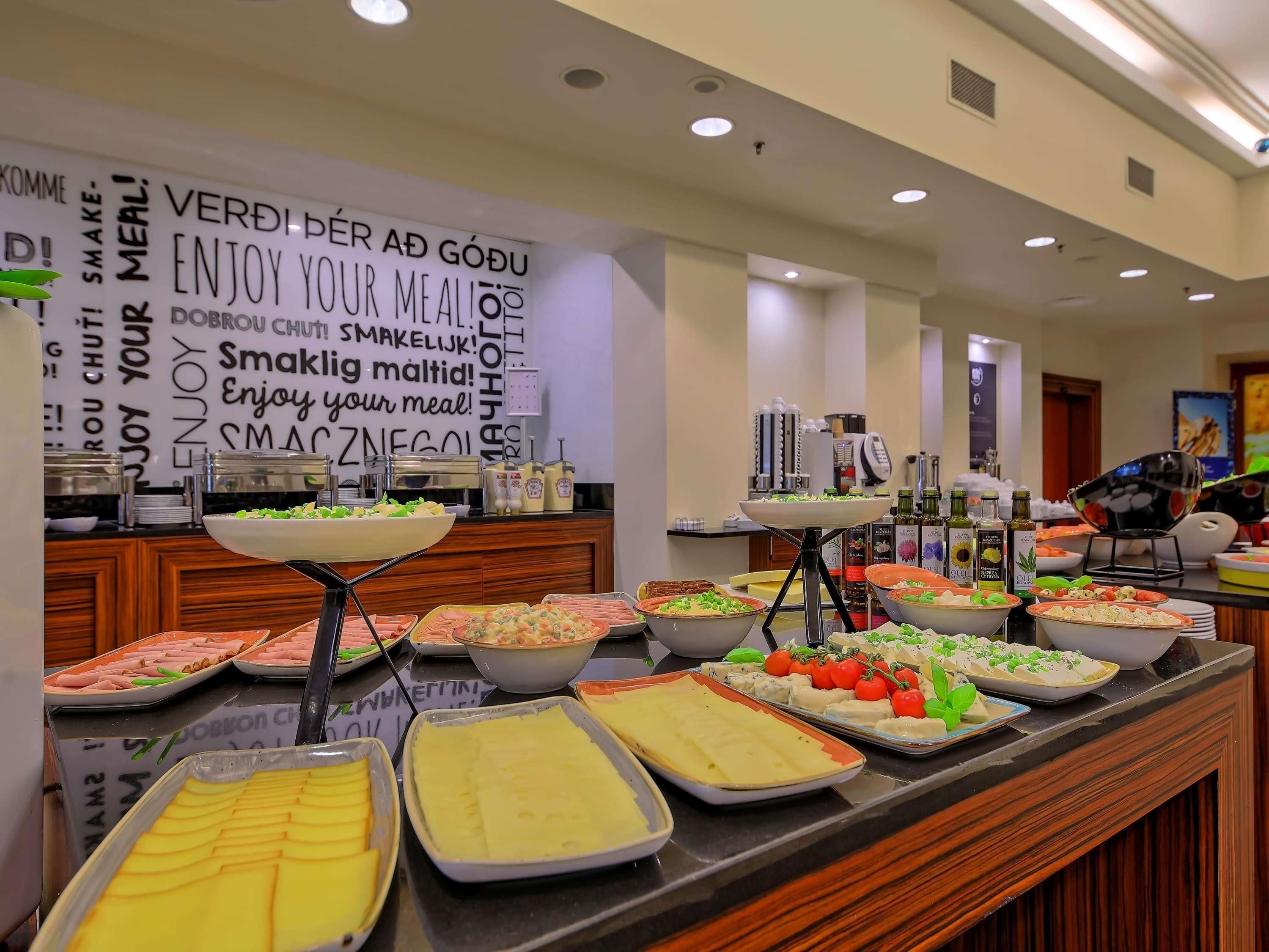 Un buffet proposant une variété de plats, accompagné d’une pancarte invitant les convives à profiter de leur repas.