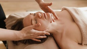 Une personne allongée, les mains posées sur la tête et la nuque, ce qui suggère une séance de massage ou de relaxation.