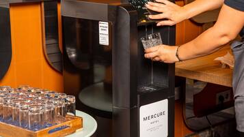 A person using a water dispenser at a hotel.
