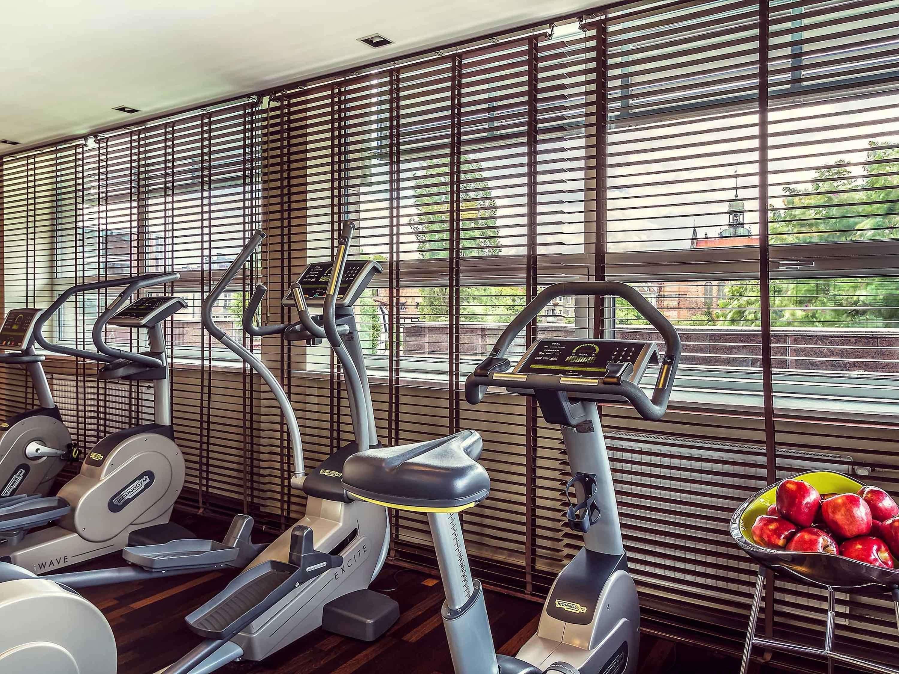 Un gimnasio con bicicletas estáticas y un cuenco de manzanas.