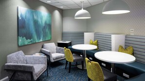 A modern lounge area with seating arrangements, including sofas and chairs, and a large abstract painting on the wall. - Hampton Inn & Suites by Hilton Miami-Doral/Dolphin Mall (Miami)