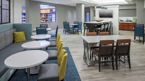 A hotel lobby with seating areas, a dining area, and a kitchenette. - Hampton Inn & Suites by Hilton Miami-Doral/Dolphin Mall (Miami)
