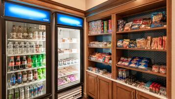 A self-service beverage station with refrigerated and frozen options, and shelves stocked with snacks and beverages.