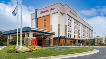 Welcome to Hampton Inn, featuring a striking entrance with a blue canopy and red telephone booth.