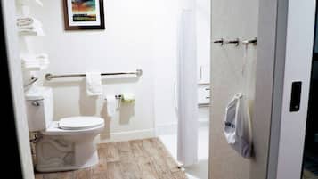 Een badkamer met toilet, handdoekrek en een ingelijst beeld aan de muur.