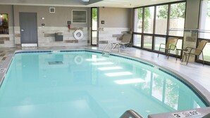 Une piscine intérieure à l’eau claire, dotée d’un poste de surveillance pour le sauveteur et d’une porte.