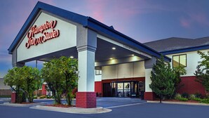 Un Hampton Inn & Suites con ingresso accessibile, facciata ben illuminata e cartello accogliente.