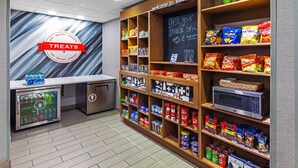 Un chiosco con snack e bevande, con una selezione di prodotti e un forno a microonde.