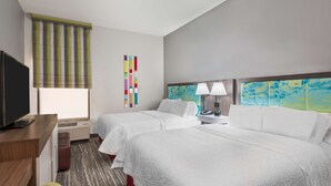 A hotel room with two beds, a desk with a TV, a lamp, and a wall with colorful artwork. - Hampton Inn Ellenton/Bradenton (Ellenton)