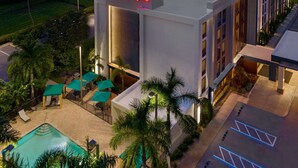 A Hampton Inn with a swimming pool, outdoor seating, and palm trees. - Hampton Inn Ellenton/Bradenton (Ellenton)