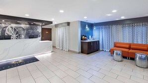 Un moderno vestíbulo de hotel con mostrador de recepción, un sofá y una zona de bar.