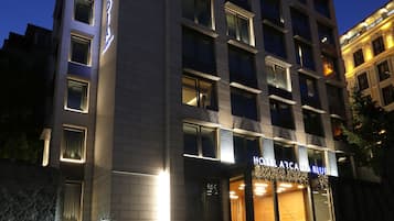 A multi-story hotel with a prominent sign reading "HOTEL ARCADIA BLUE".