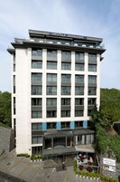 Un hôtel doté d’un restaurant situé au dernier étage, avec un design moderne, de grandes fenêtres et un balcon.