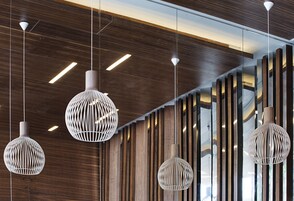 Un interno moderno con pareti rivestite in legno e lampade sferiche a sospensione.