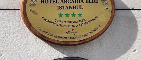 Two plaques: one for Hotel Arcadia Blue Istanbul with a green star rating and an environmental award, and another for Safe Tourism certification in Turkey.