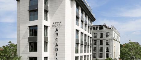 Un hotel de varios pisos con un letrero llamativo que dice "ARCADIA HOTEL".