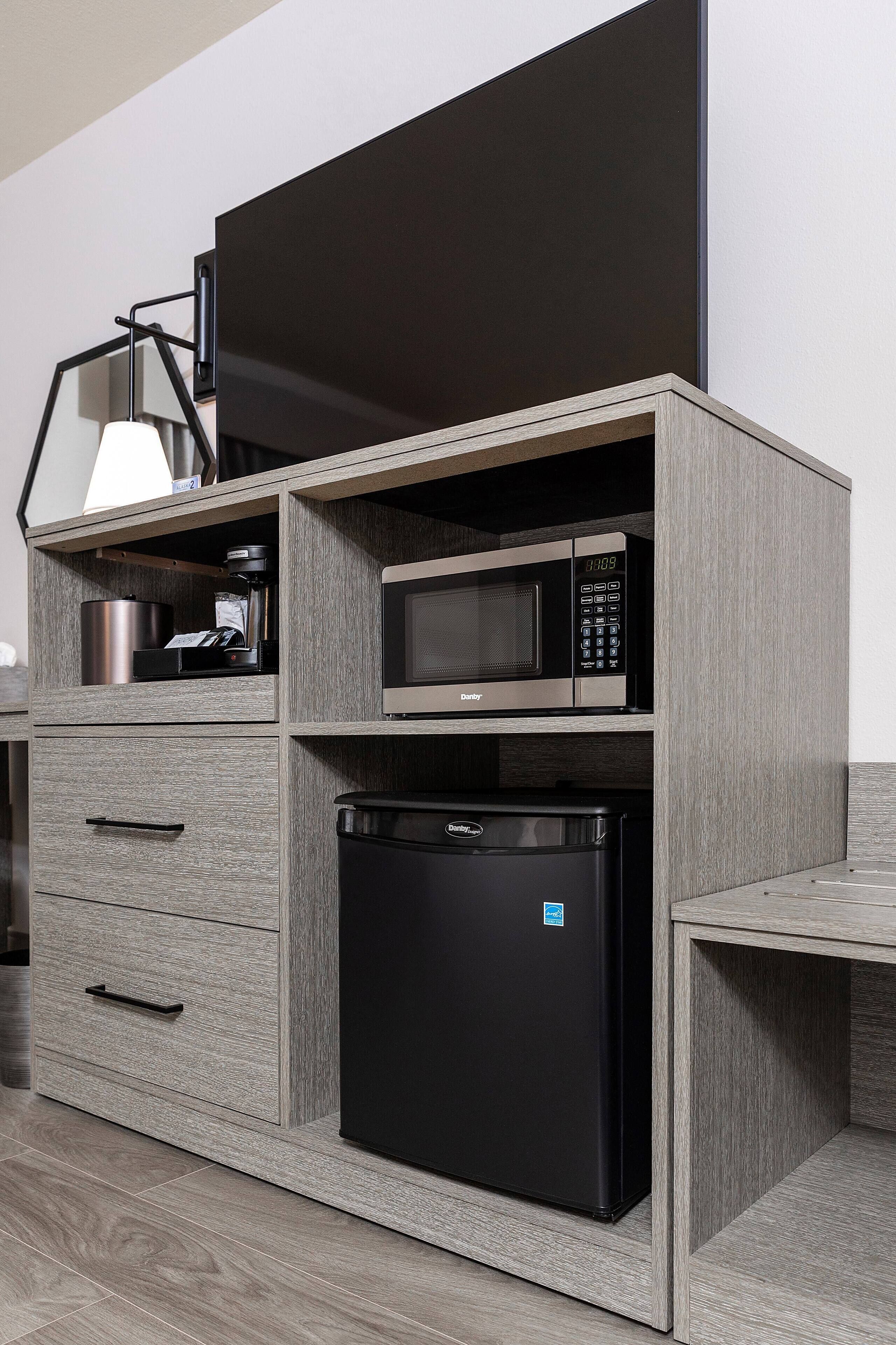 Una cocina compacta equipada con microondas, cafetera y lavavajillas.