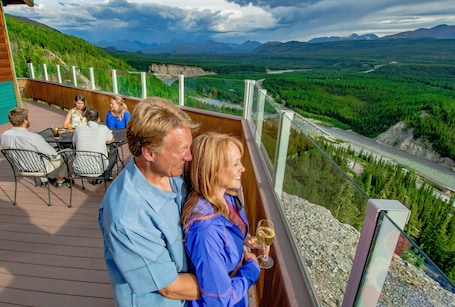 A deck with outdoor seating overlooking a scenic landscape.