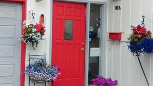A red door with a small window above it, a mailbox, and a number '2107' on the wall. - Alaska European Bed & Breakfast (Anchorage)