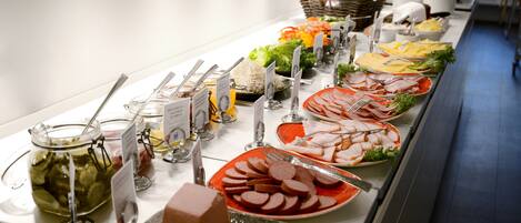 A buffet with various food items and utensils.