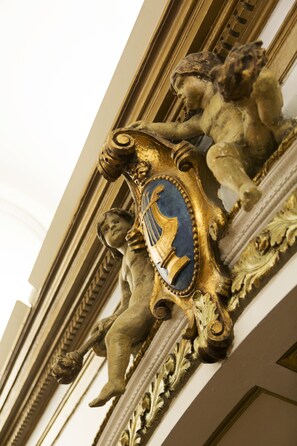 A detailed architectural feature with ornate carvings and a shield emblem. - Elite Stora Hotellet Linköping (Linkoping)