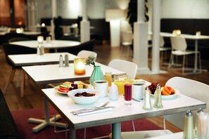 A dining area with tables set for breakfast, including bowls of cereal, fruits, and beverages. - Elite Stora Hotellet Linköping (Linkoping)