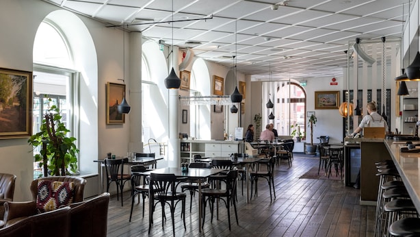 A spacious restaurant with high ceilings, wooden floors, and modern pendant lighting. - Elite Stora Hotellet Linköping (Linkoping)