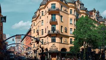 A historic building with a prominent entrance, multiple balconies, and a sign indicating it is a hotel.