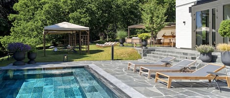 Una piscina al aire libre, tumbonas