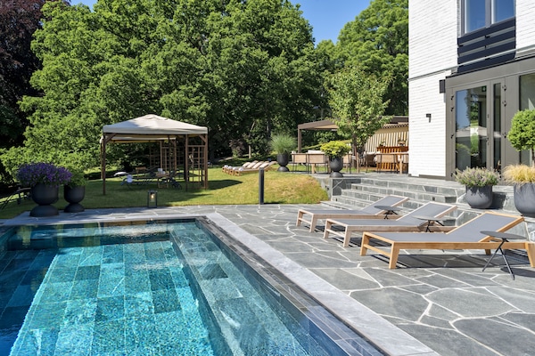 Una piscina al aire libre, sillones reclinables de piscina