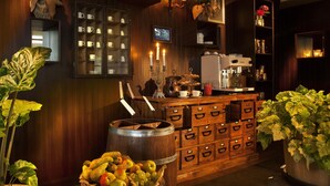 A cozy bar area with wooden cabinets, a coffee machine, and a fruit bowl. - Villa Lovik (Lidingo)
