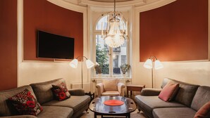 Una sala de estar con un sofá, un sillón y una mesa con un objeto rojo.