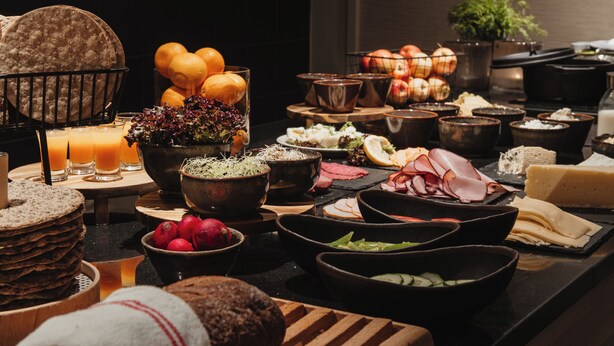 Un bufé con diversos alimentos, como frutas, verduras y carnes.