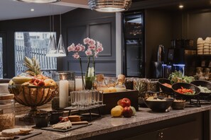 A modern kitchen with a fruit bowl, glassware, and various food items on the counter. - Home Hotel Kung Oscar (Trollhattan)