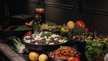 A variety of dishes and fresh vegetables on a table in a kitchen setting.