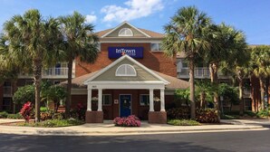 A brick building with a sign for InTown Suites.