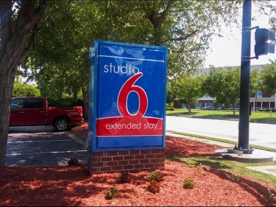 A sign for 'Studio 6 Extended Stay' with a brick base and blue background.