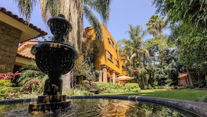 A fountain in a courtyard with a building in the background. - La Mansiรณn del Sol (Zapopan)