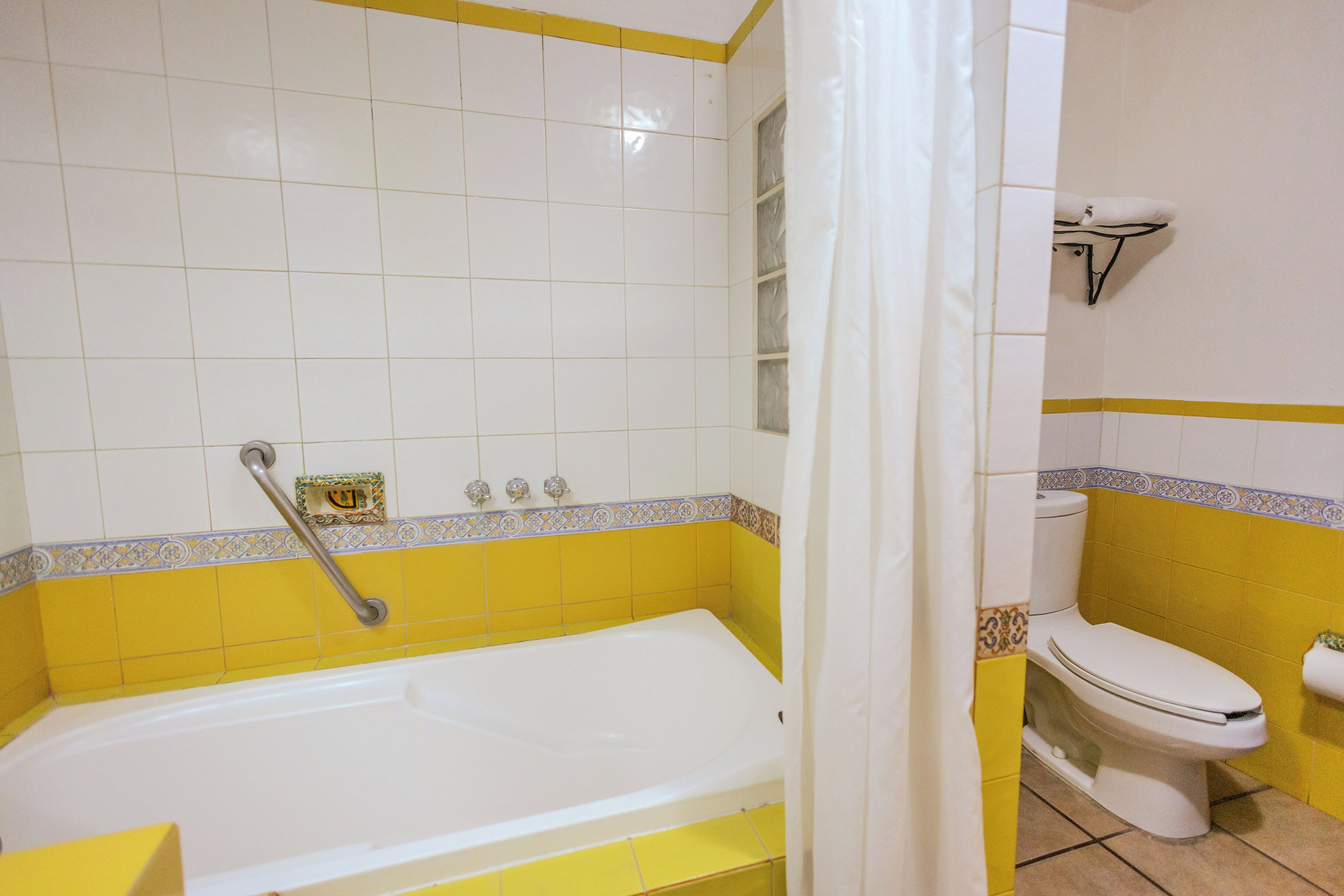 Een badkamer met een bad, toilet en een douchegordijn.