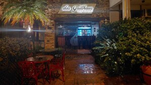 Un restaurante llamado 'das Grillhaus' con terraza y fachada de piedra.