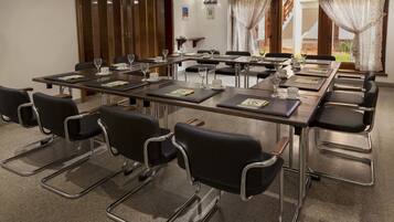 A conference room with a long table, black chairs, and a wooden door.
