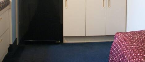 A compact kitchenette with a microwave, coffee maker, and dishwasher.