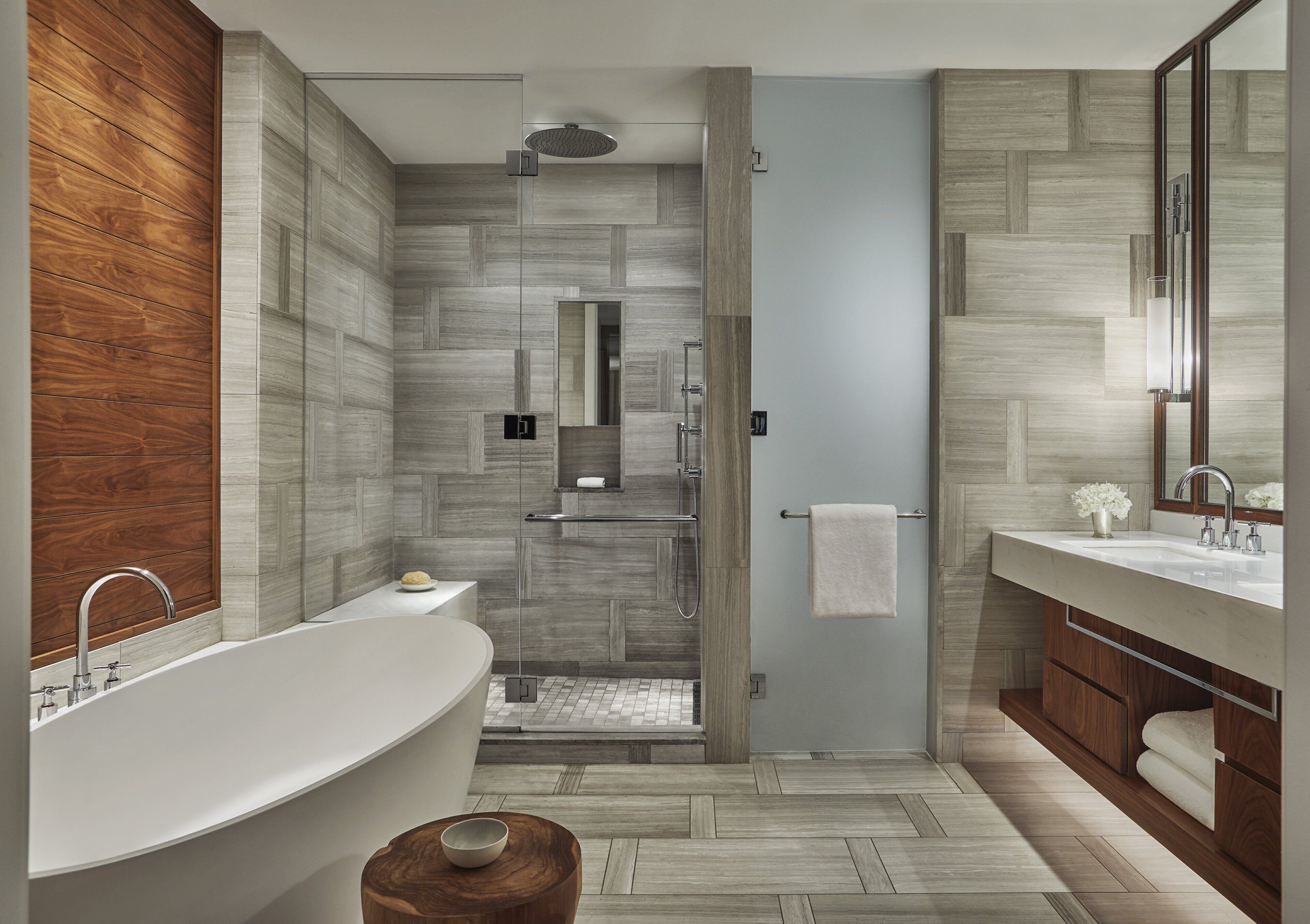 A modern bathroom with a freestanding bathtub, a walk-in shower, and a vanity with a mirror.