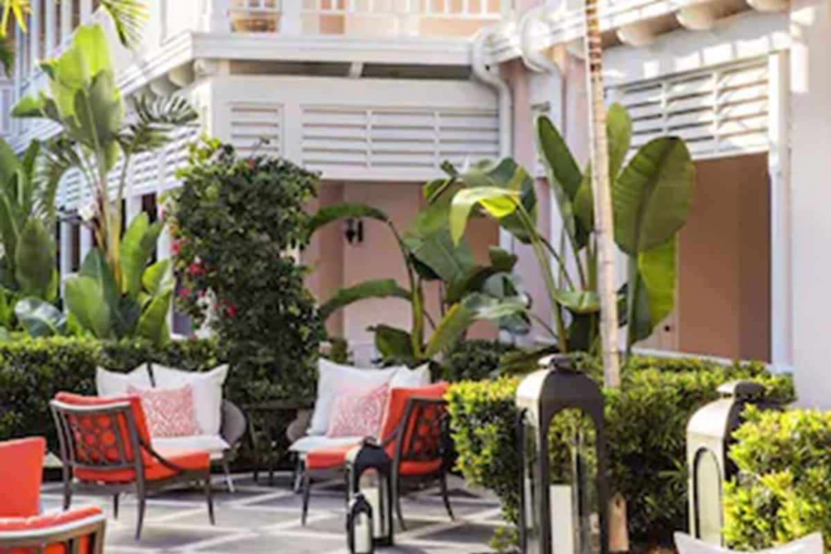 A spacious outdoor patio with wicker furniture and a pool.