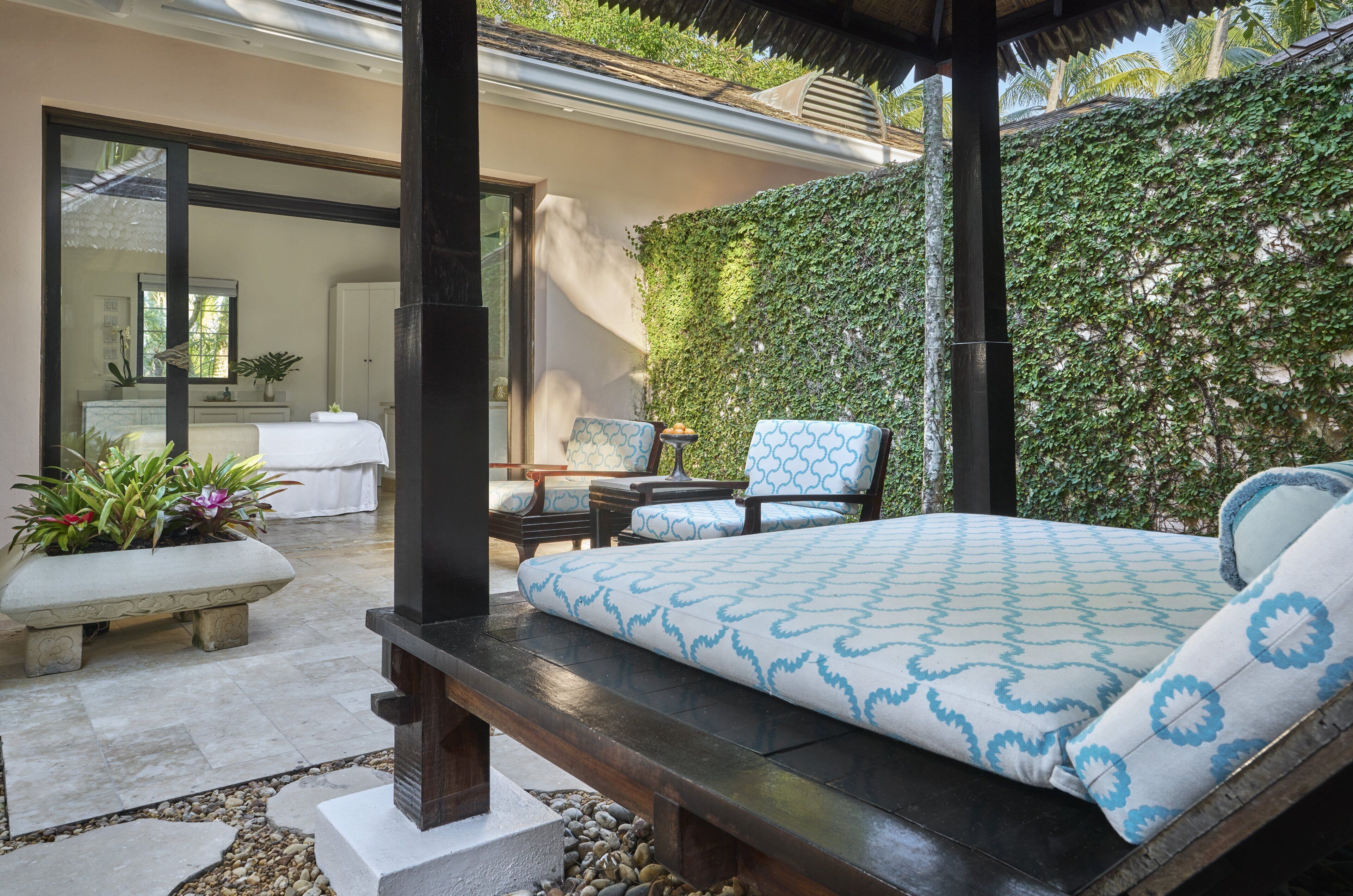 A bedroom with a bed, a bench, and a chair. There is a window and a door.