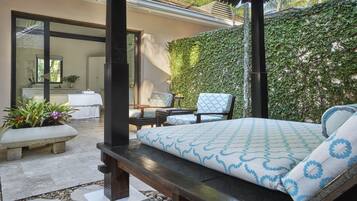 A bedroom with a bed, a bench, and a chair. There is a window and a door.
