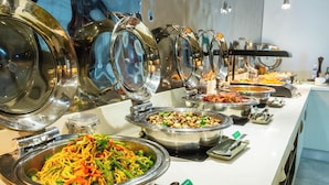 Un bufé con diversas opciones de comida, como fideos, ensaladas y otros platos.